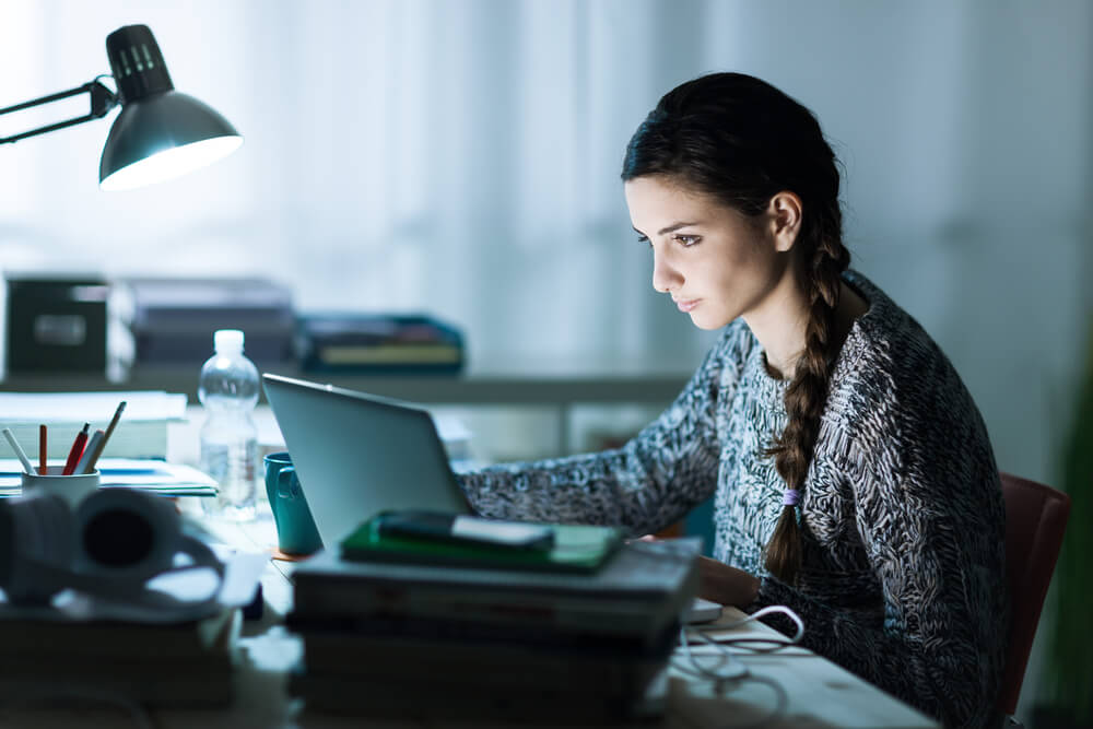 student studying at a desk during night time