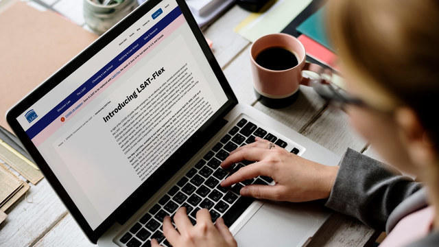 Woman on laptop reading about LSAT-Flex