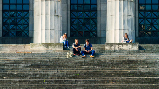 Students studying on steps of law school building