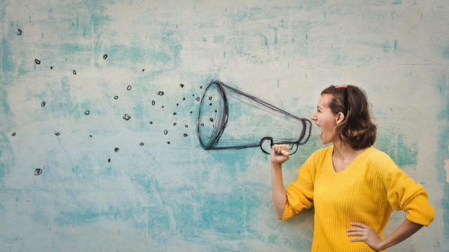 Young woman screaming into a megaphone
