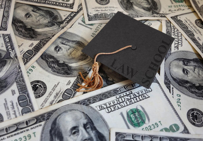Law school graduation cap on pile of cash